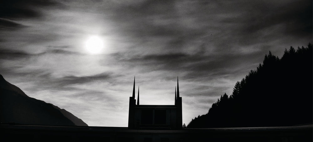 Silhouetted modern building with spires against moody sky, symbolizing transformation and growth.