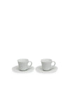 Two light grey ceramic cups by Alessi, each with a matching saucer.