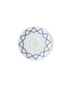 White porcelain saucer by Alessi with a blue geometric star pattern, shown from a top-down view.