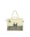 Cream-colored XL tote bag by Alessi with a black cat and building illustration and a red side tag.