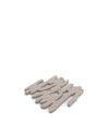 Light brown Barkforpan trivet by Alessi, with an organic, abstract cut-out design, angled view on white.