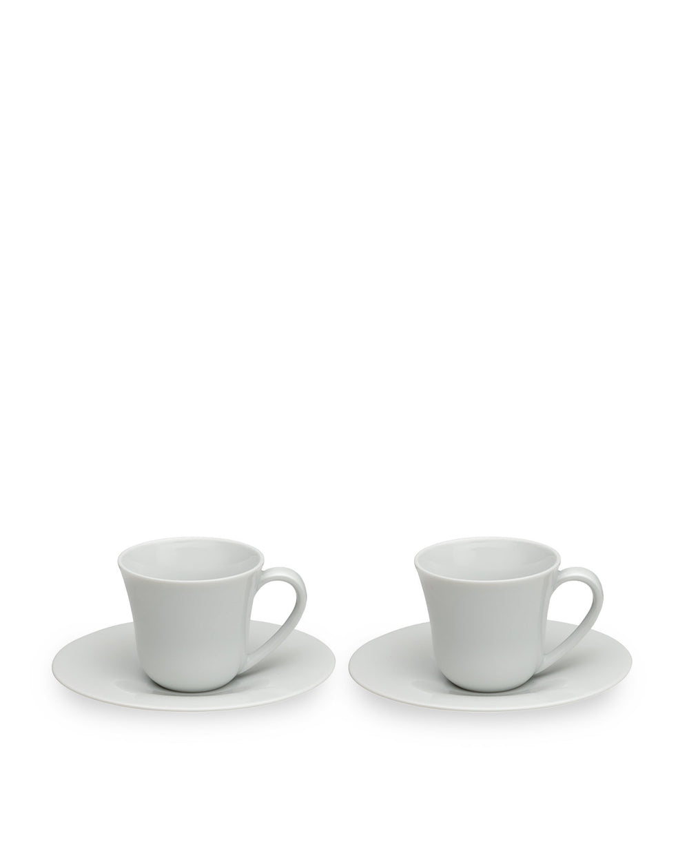 Two white ceramic cups with saucers by Alessi, featuring a simple, elegant curved design, presented at a slight angle.