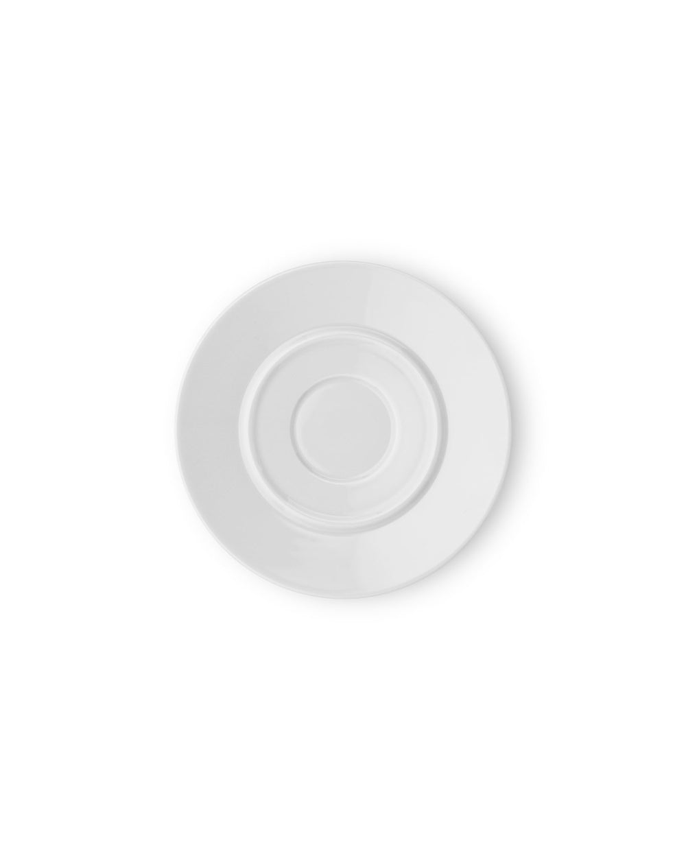 White round saucer by Alessi with concentric indentations, viewed from above, casting a soft shadow.