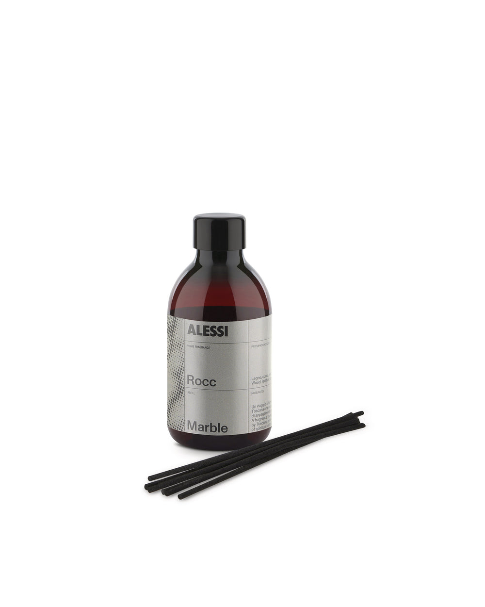 Dark amber glass fragrance diffuser by Alessi with a grey 'Rocc Marble' label and black cap, alongside black diffuser sticks.
