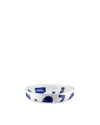 White ceramic bowl with blue abstract shapes by Alessi, shown from a slightly elevated angle.