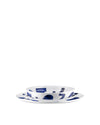 White ceramic table set by Alessi, with hand-painted blue abstract patterns on a stacked bowl and plates.