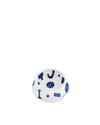 White ceramic dog bowl by Alessi, decorated with abstract blue letter-like and circular patterns.