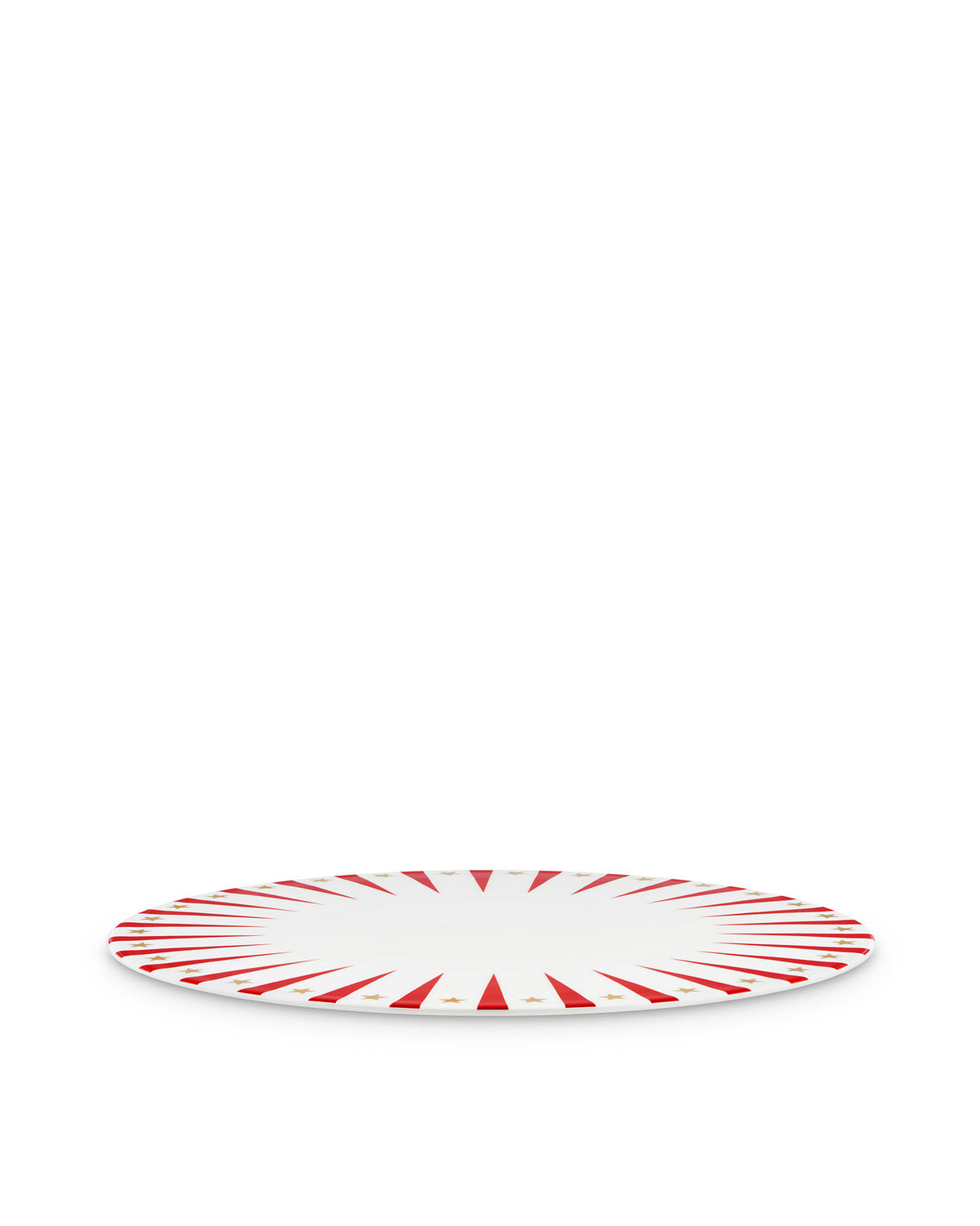 White Christmas decorative plate by Alessi with red sunburst rays and gold stars, angled view.