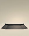 Black rectangular tray by Alessi with flared sides and a minimalist design.