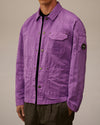 Purple crinkled jacket by Alessi with snap buttons, an embroidered C.P. Company Alessi chest pocket, and a circular sleeve patch.