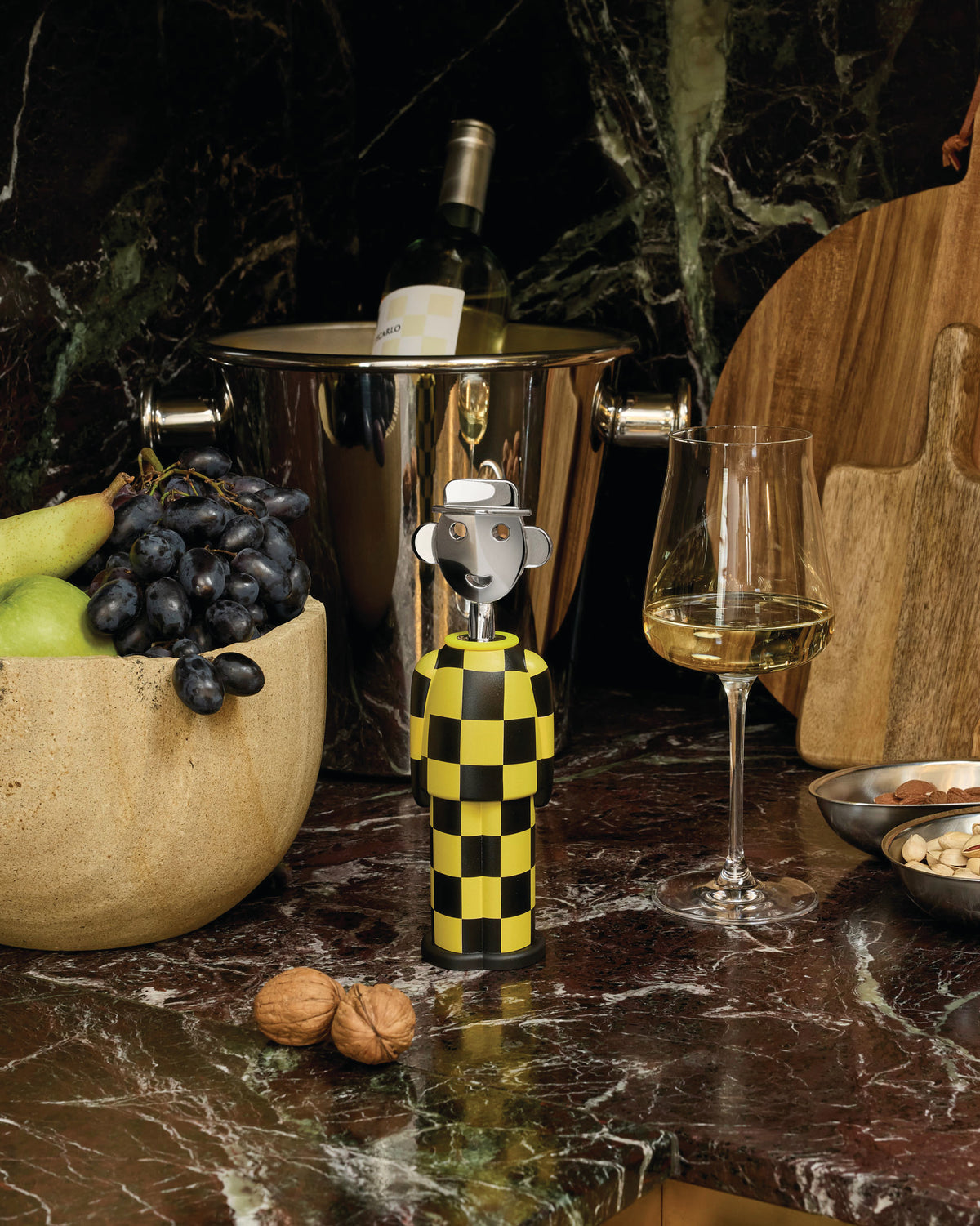 Yellow and black checkerboard corkscrew by Alessi, featuring a polished metal face.