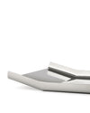 Silver metallic tray by Alessi with a sleek, modern design and reflective surface, viewed from a low angle.