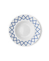 White ceramic soup bowl by Alessi with a blue geometric zigzag pattern around the rim, viewed from above.