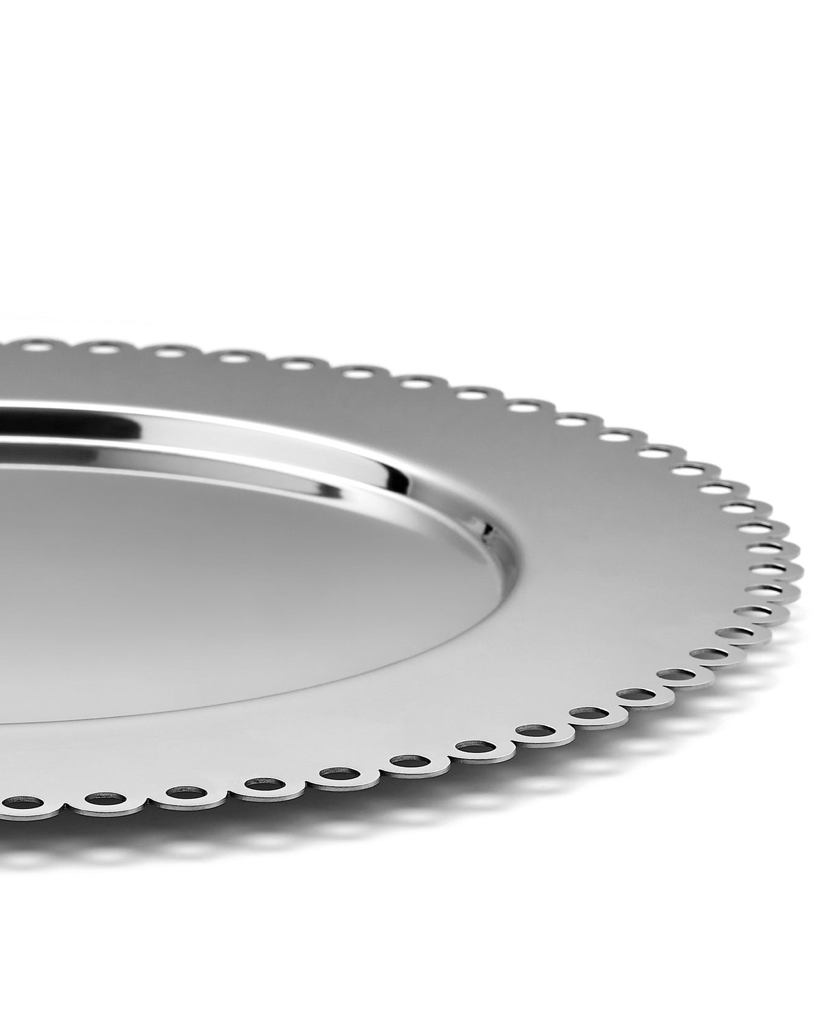 Silver metallic tray by Alessi with a decorative scalloped edge and small cutouts, viewed from an angle.
