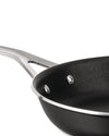Black frying pan with a silver handle by Alessi, featuring a textured non-stick interior, shown cropped at an angle.