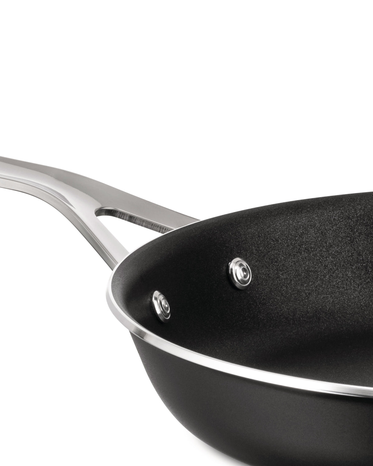 Black frying pan with a silver handle by Alessi, featuring a textured non-stick interior, shown cropped at an angle.