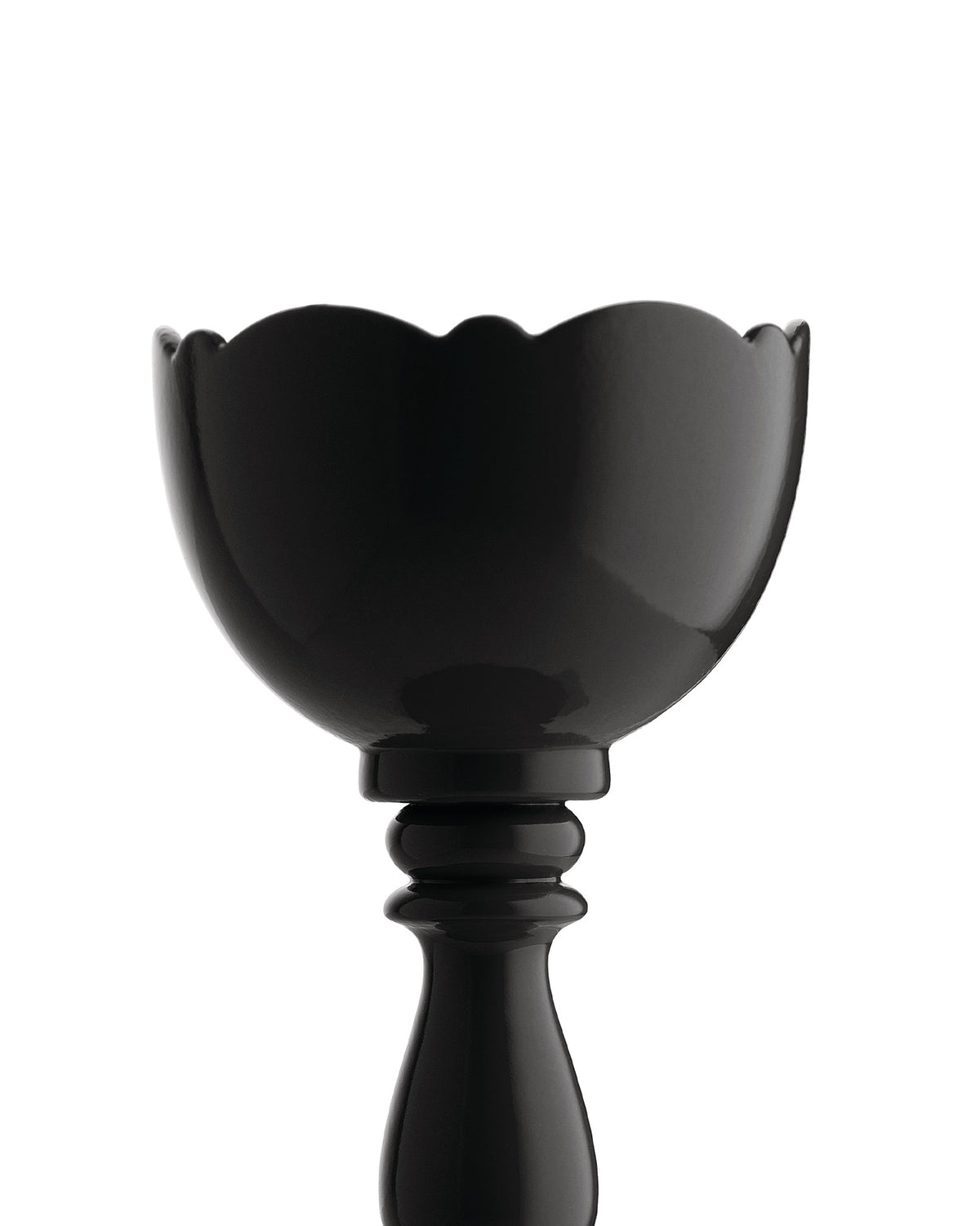 Glossy black egg cup by Alessi with a scalloped rim and a tall pedestal base against a white background.