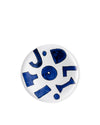 White ceramic plate by Alessi featuring an abstract blue painted design with letter-like shapes.