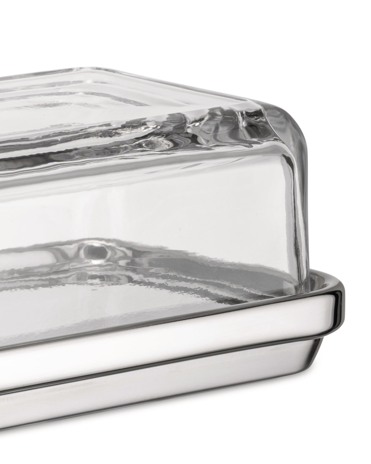 Glass and polished silver-tone butter dish by Alessi with a clear rectangular glass cover, viewed from the side.