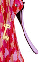 Pink and red patterned Anna G. corkscrew by Alessi, with a shiny purple arm and a gold key necklace.