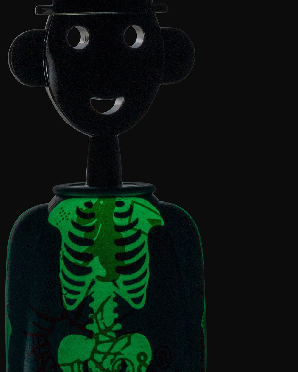Black anthropomorphic corkscrew by Alessi with a smiling face, hat, and glowing green skeleton design.