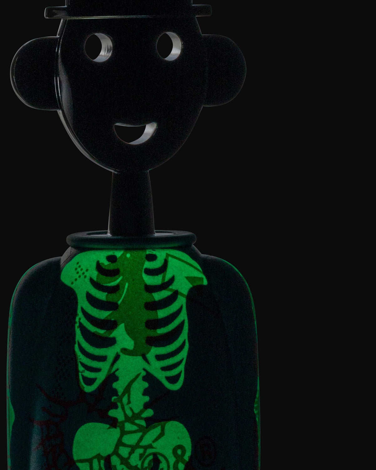 Black anthropomorphic corkscrew by Alessi with a smiling face, hat, and glowing green skeleton design.