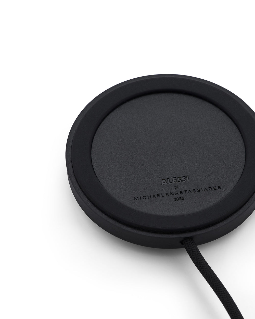 Black round Halesia lamp by Alessi, with a textured surface, a braided cord, and embossed designer names.