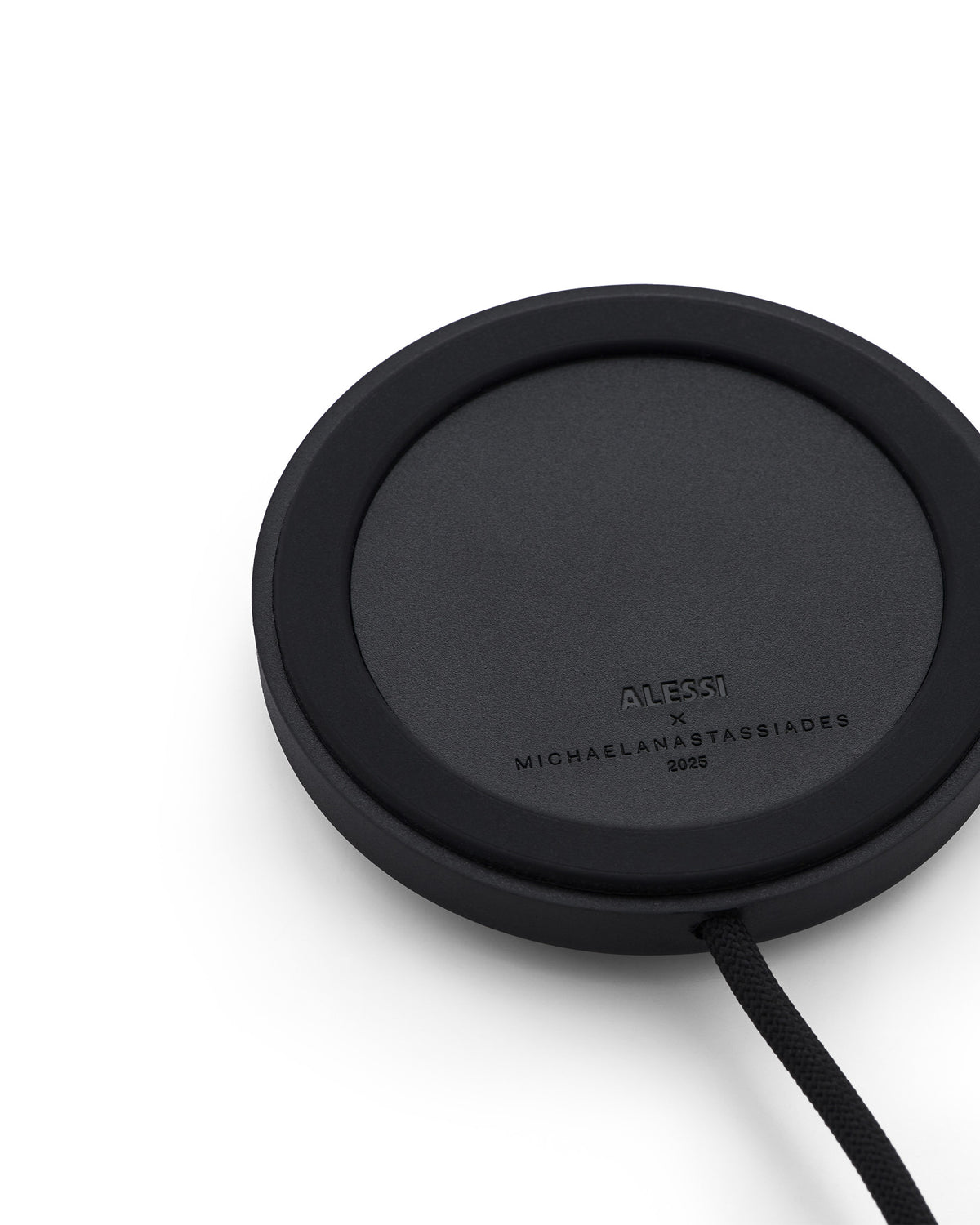 Black round Halesia lamp by Alessi, with a textured surface, a braided cord, and embossed designer names.