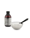 Silver bowl-shaped fragrance diffuser by Alessi with black sticks and a brown refill bottle.