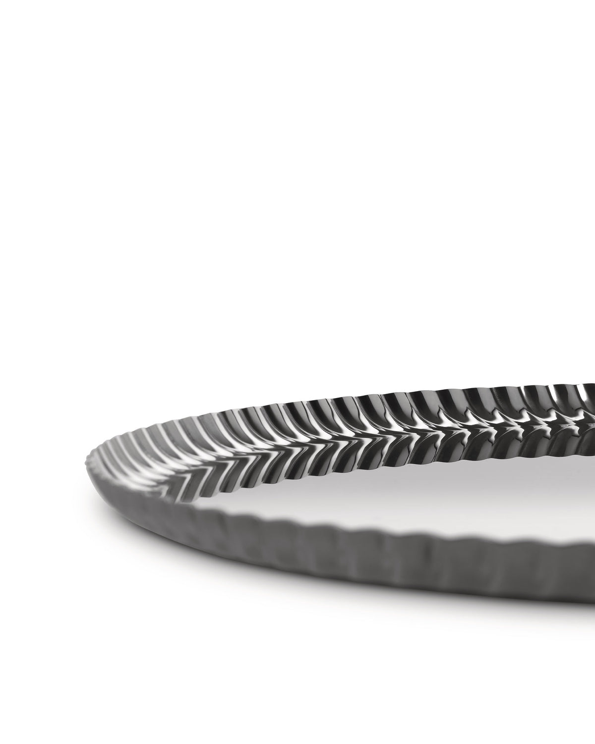 Dark grey metallic tray by Alessi with a distinctive pleated wavy rim, shown from a low angle.
