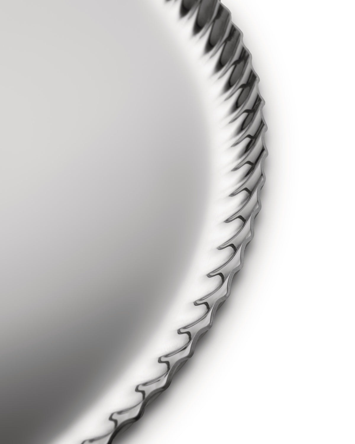 Silver metallic tray by Alessi with a decorative pleated edge, cropped view on a white background.