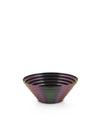 Iridescent metallic bowl by Alessi with concentric rings on a white background.