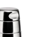 Stainless steel cocktail shaker by Alessi with a brushed finish and a unique ergonomic indentation, shown in a close-up.