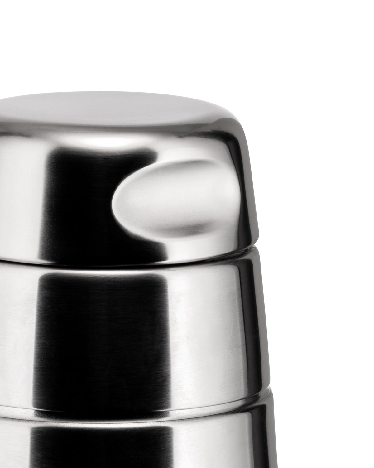 Stainless steel cocktail shaker by Alessi with a brushed finish and a unique ergonomic indentation, shown in a close-up.