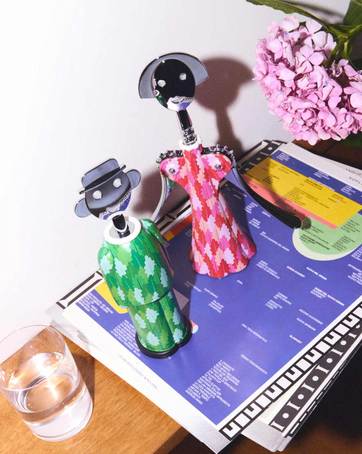 Pink and red patterned Anna G. corkscrew by Alessi, a stylized female figure, standing with a green corkscrew.