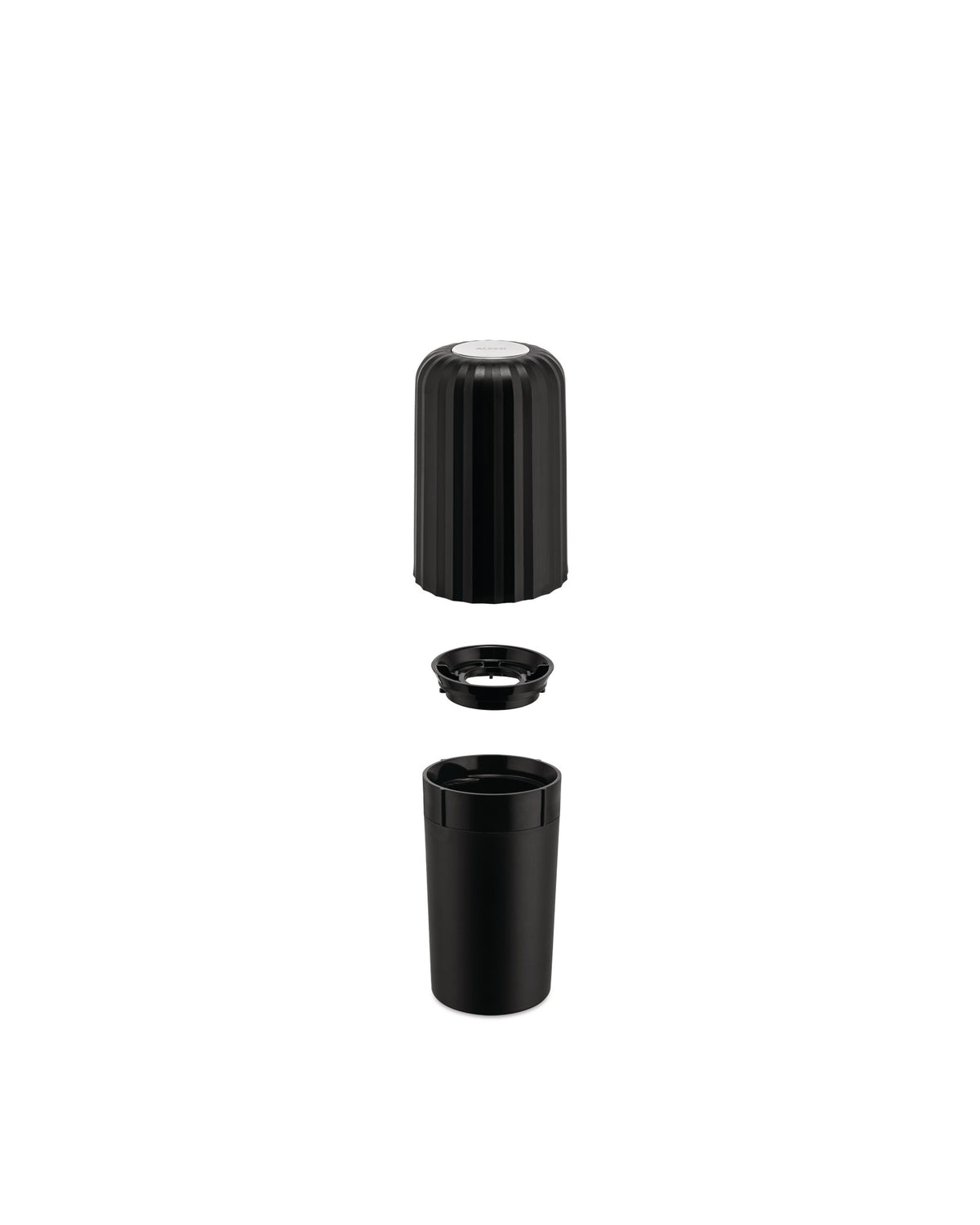 Black plastic capsule crusher by Alessi disassembled into three ribbed pieces.