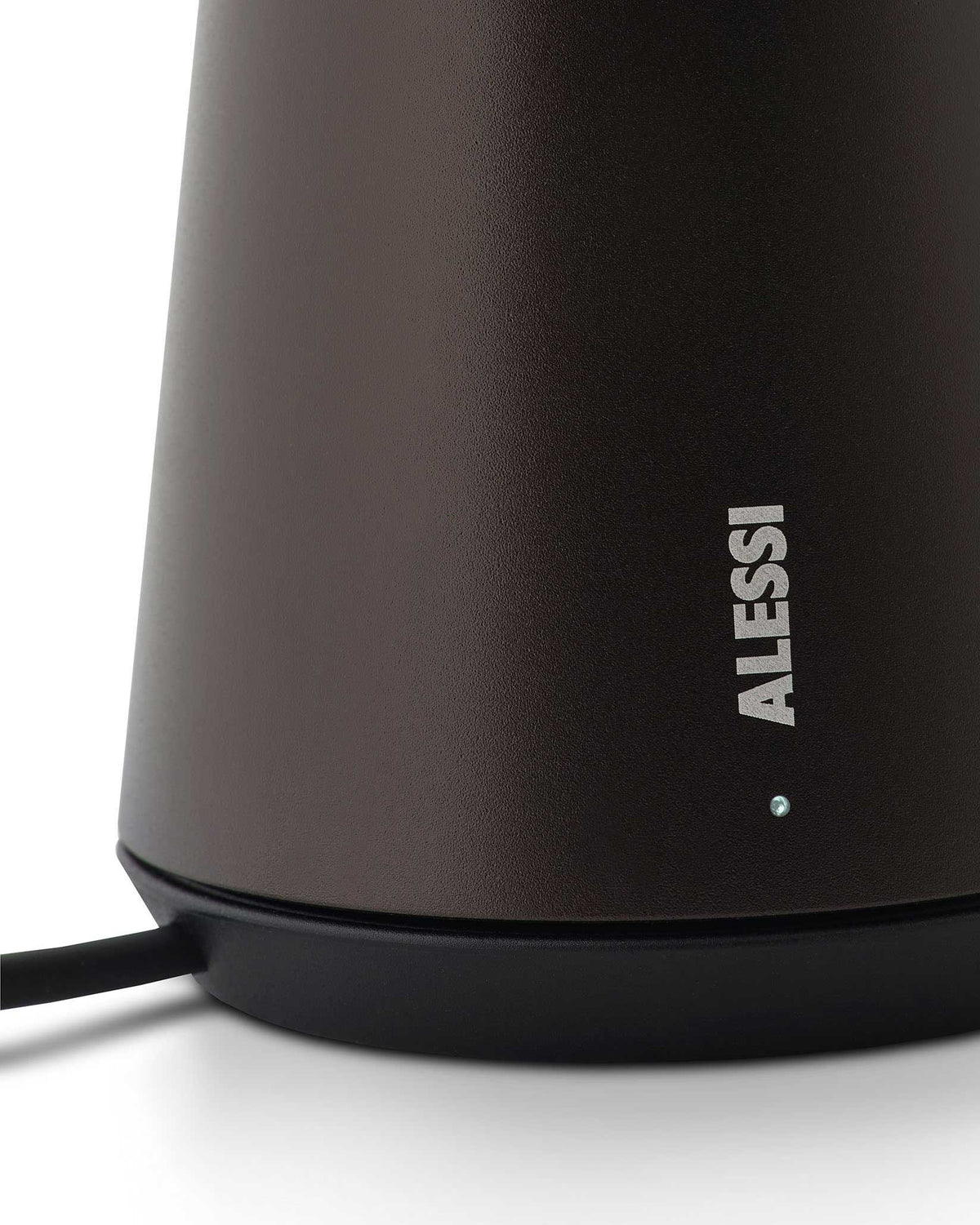 Matte dark brown textured Bedin lamp by Alessi, close-up showing the ALESSI logo and an illuminated light on a black base.