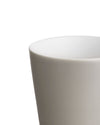 Light gray ceramic cup by Alessi with a smooth matte finish and white interior, cropped.