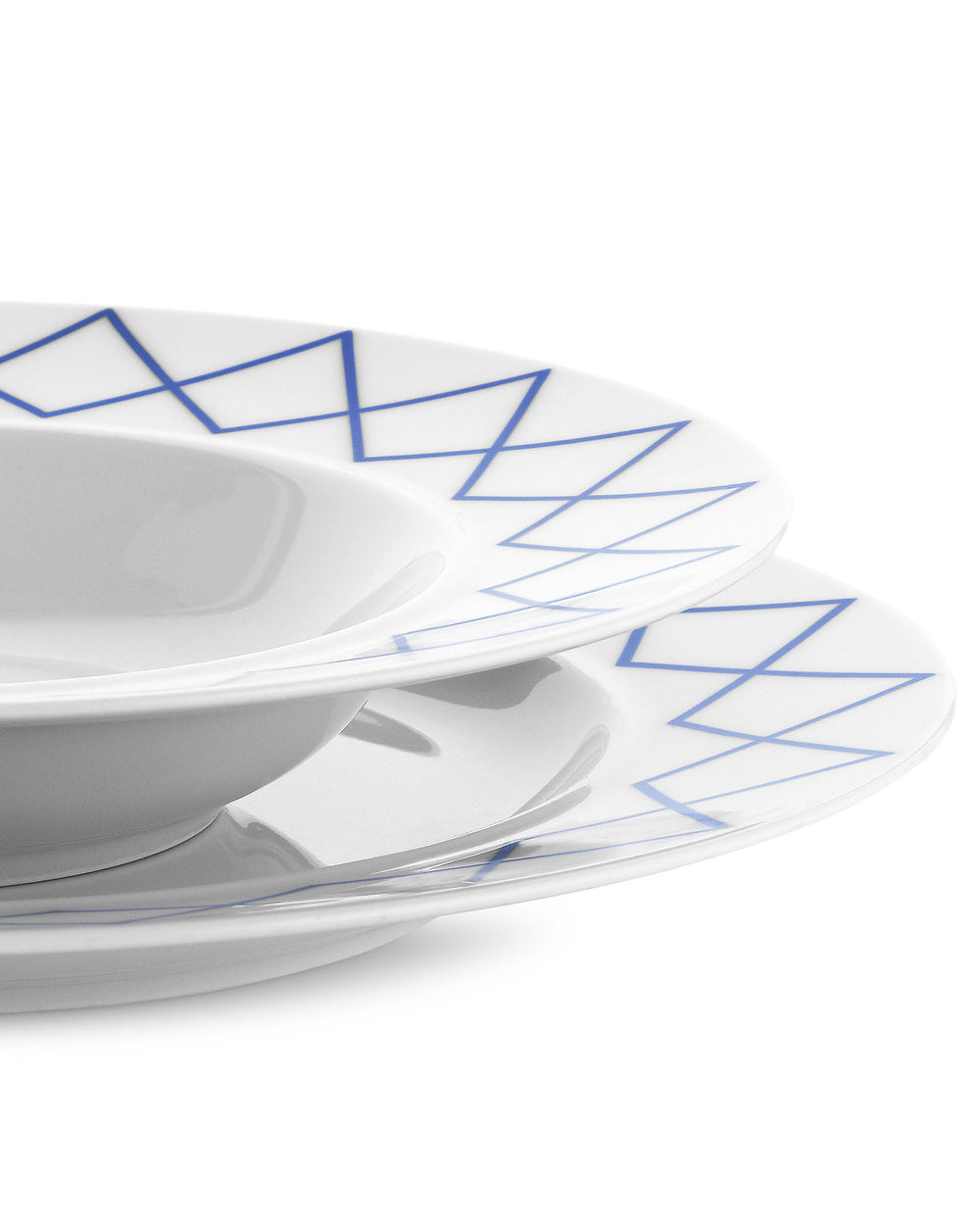 White ceramic soup bowls by Alessi with a blue geometric line pattern on the rim, stacked diagonally.
