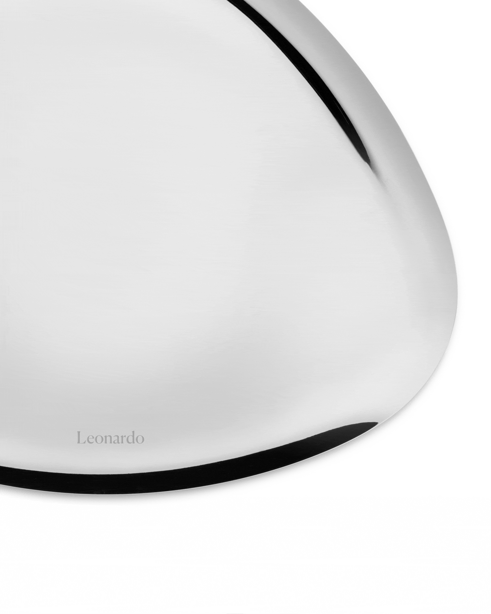 Silver metal platter by Alessi with a black curved edge and 'Leonardo' engraved on its reflective surface.