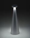 Gray conical Bedin lamp by Alessi, with a dark flat top emitting a bright downward light beam.