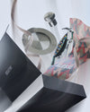 Colorful dotted parrot corkscrew, silver stopper, and coaster mixology set by Alessi, presented with a black box and geometric wrapping paper.