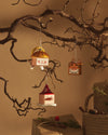 Colorful Cubocchio character Christmas tree ornaments by Alessi, showing smiling, long-nosed, and tiger designs hanging from branches.
