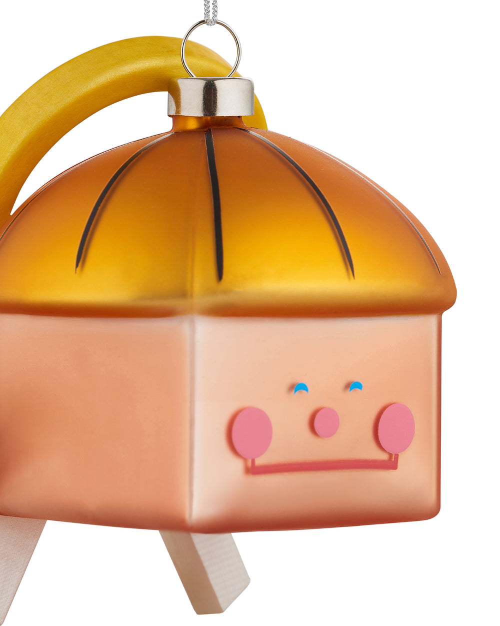 Frosted orange Christmas tree ornament by Alessi with a whimsical cartoon face, yellow arched handle, and wooden legs.