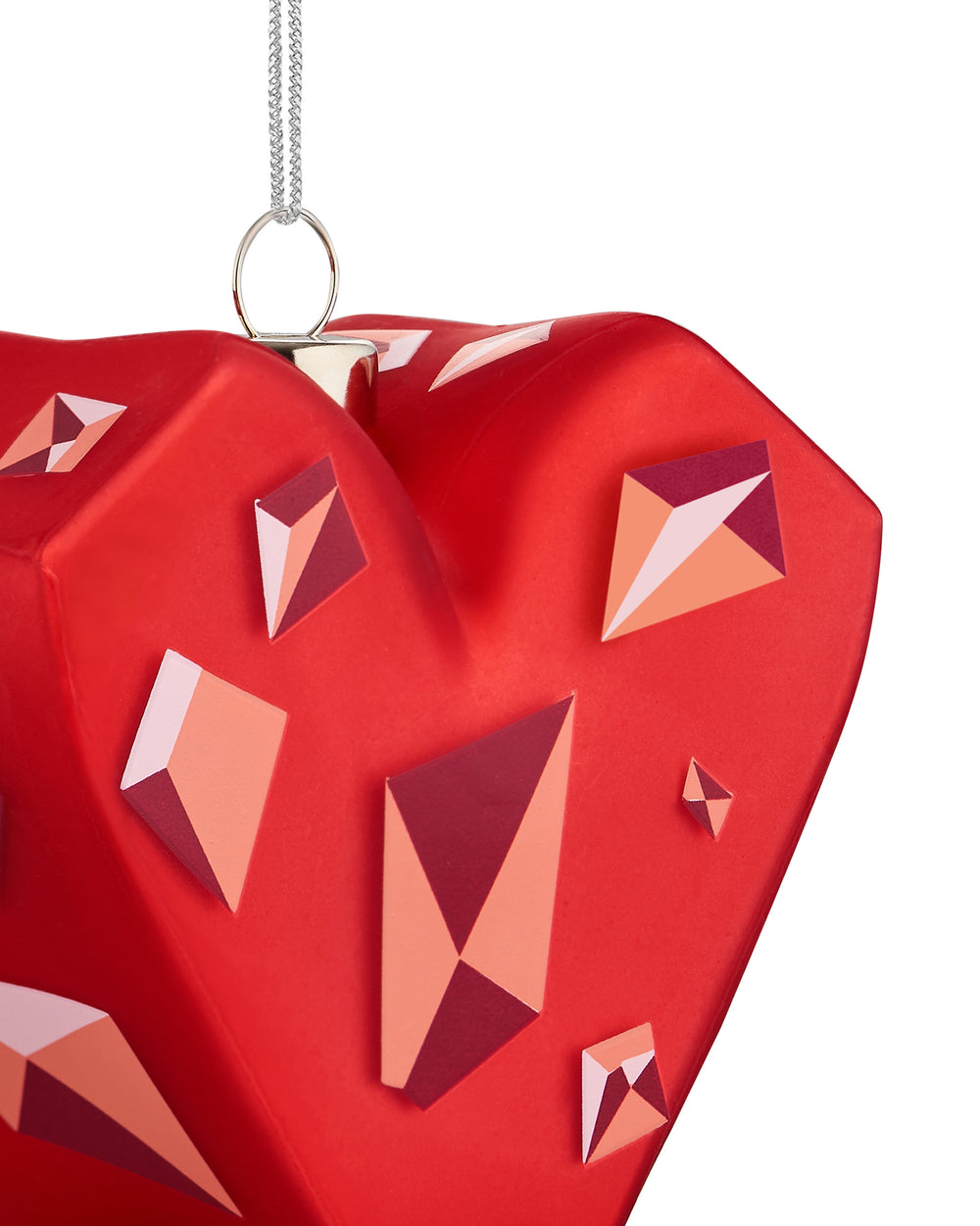 Red faceted heart-shaped Christmas tree ornament by Alessi, decorated with geometric patterns in pink, orange, and burgundy.