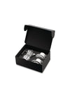 Open black coffee gift set by Alessi with a silver ribbed moka pot and two white cups with curved saucers.