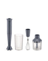 Dark grey hand blender by Alessi with clear ribbed measuring cup, whisk, and chopper attachments.
