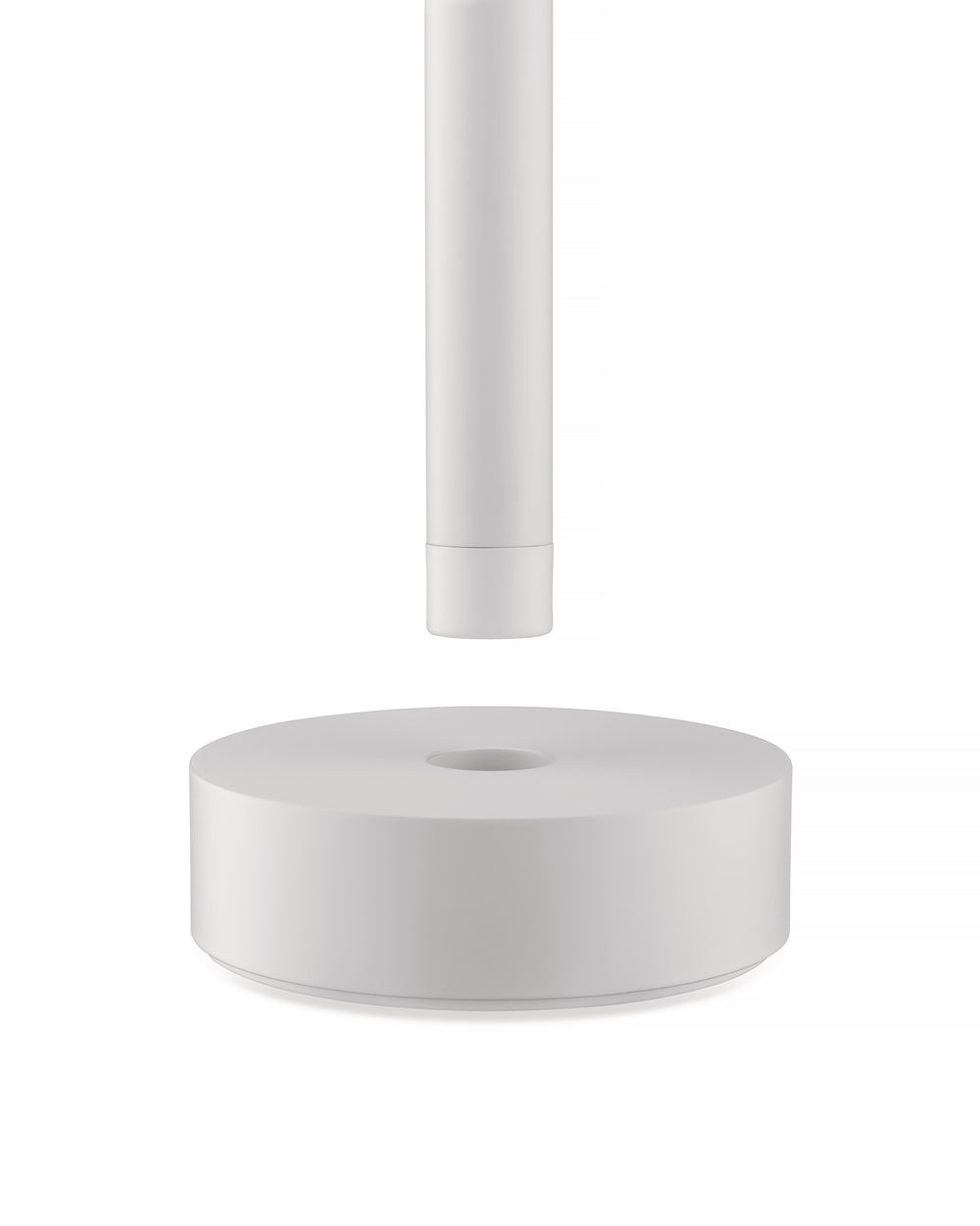 White Tsumiki lamp by Alessi, featuring a cylindrical part above a round base with a central opening.