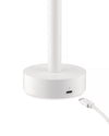 White cylindrical Tsumiki lamp by Alessi with a visible USB-C port on its round base, connecting to a braided white cable.