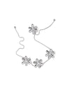 Tripod trivet by Alessi, composed of six reflective silver jack-like elements linked by a delicate chain.
